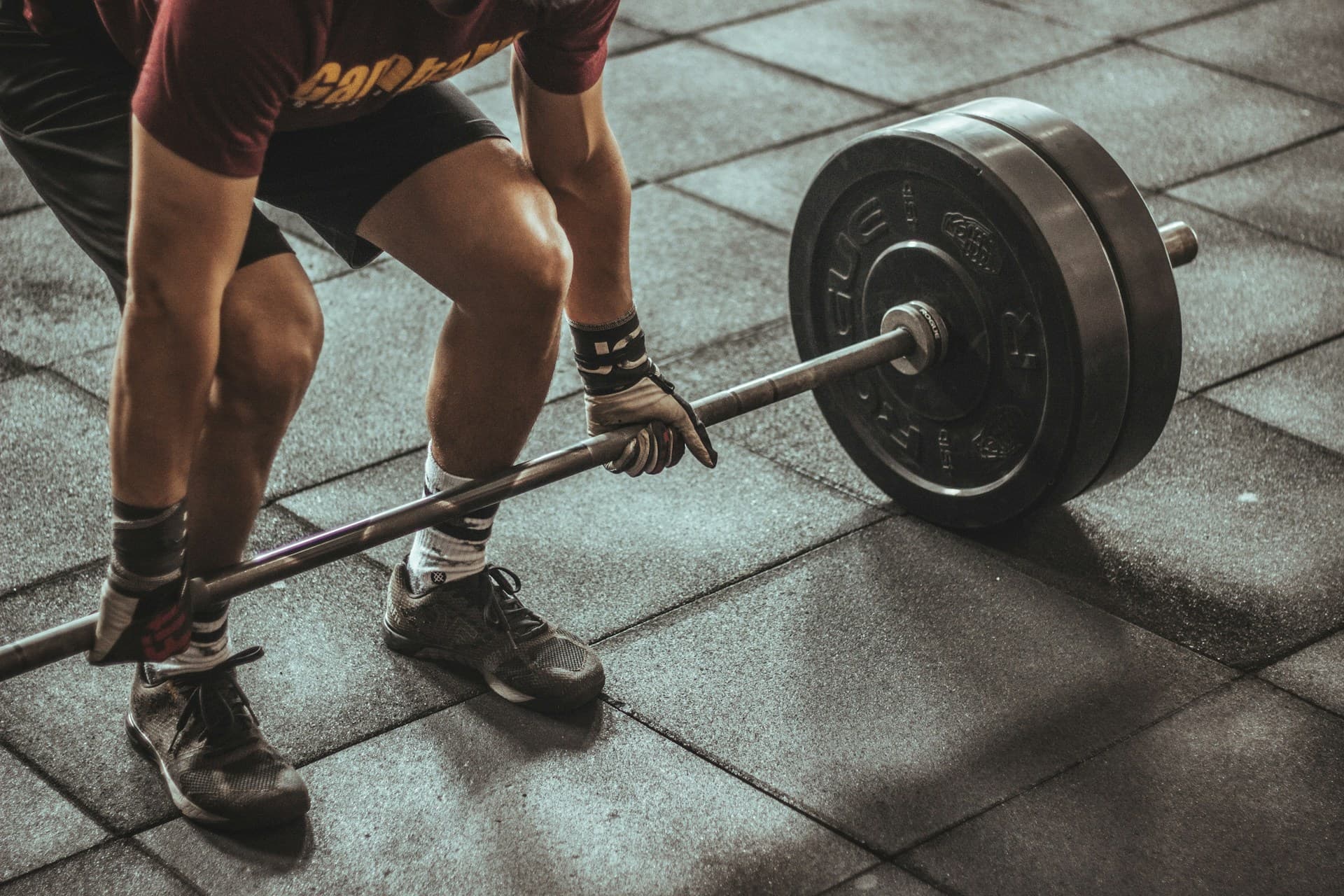 An athlete preparing to lift a barbell in a gym